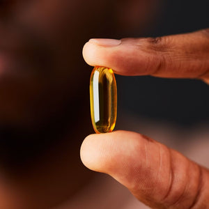 Solgar Double Strength Omega-3 Softgel in a person's hand