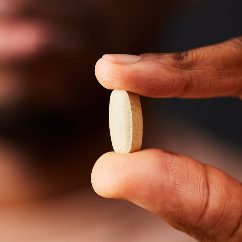 Solgar ester c vitamin c tablets in a person's hand