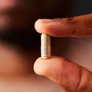 Solgar Earth Source Food Fermented Koji Iron tablet in a person's hand