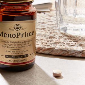 Solgar MenoPrime Menopause Tablets in a glass jar on a table