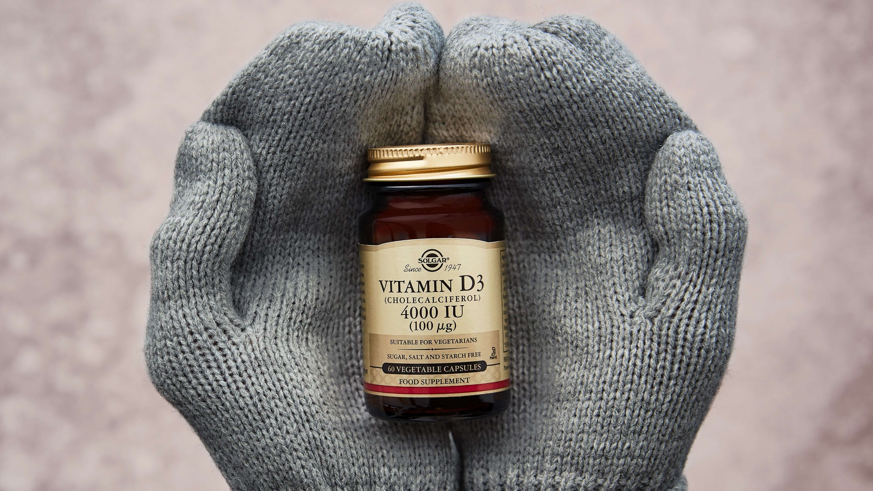 Solgar Vitamin D3 tablets in some hands wearing gloves