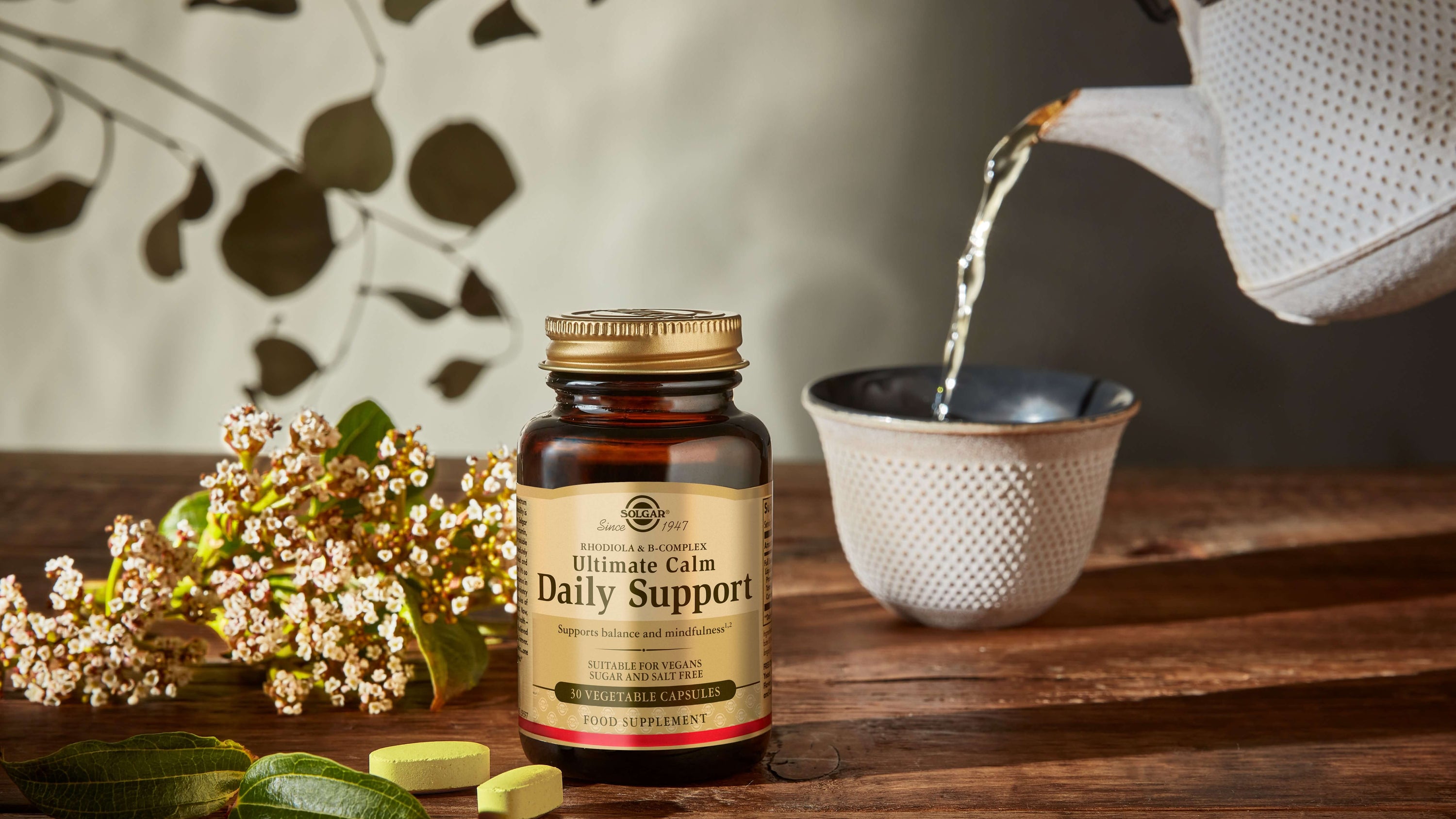 Solgar Ultimate Calm Daily Support Capsules on a wooden table with a cup of tea