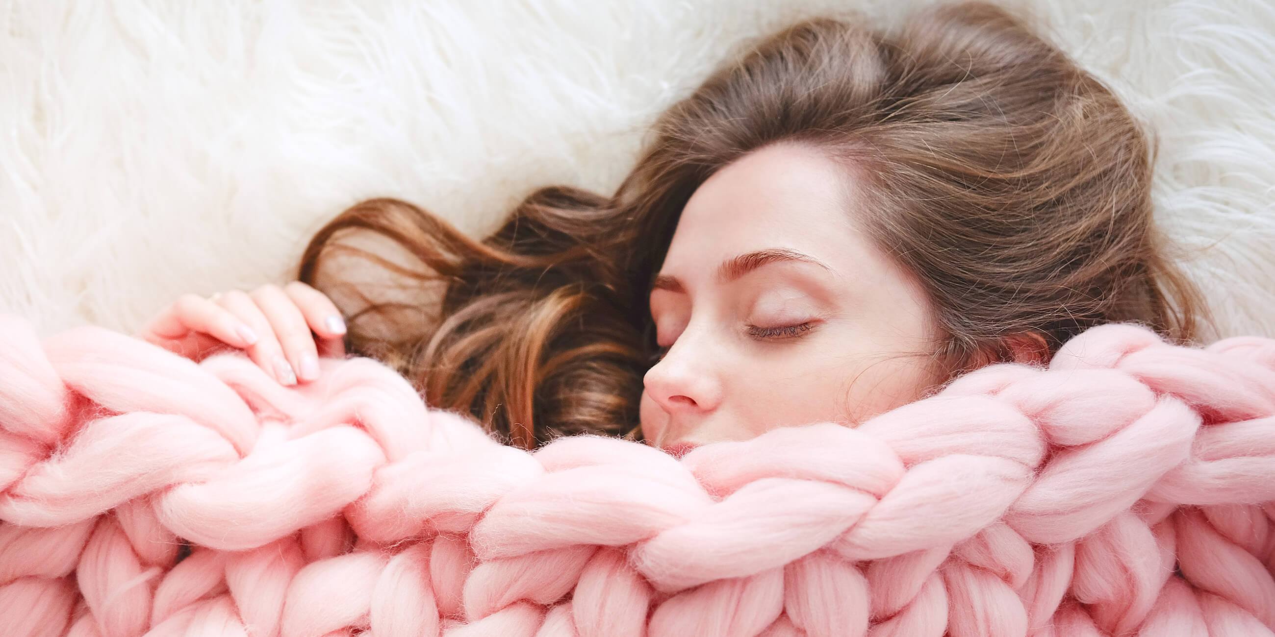 Girl sleeping with a pink blanket over her mouth with clear skin