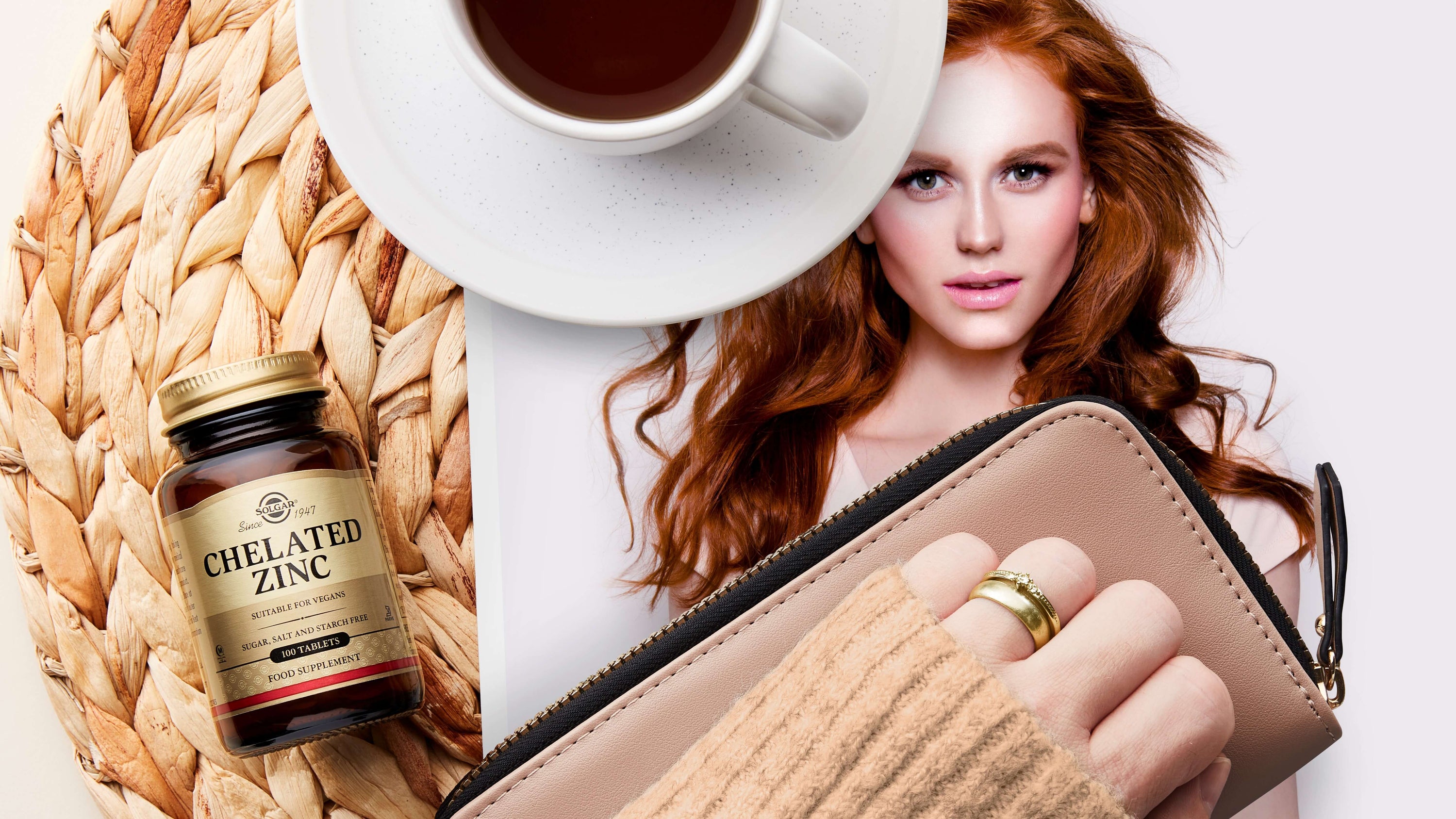 Solgar Chelated Zinc Tablets on a tablet with a magazine and a purse
