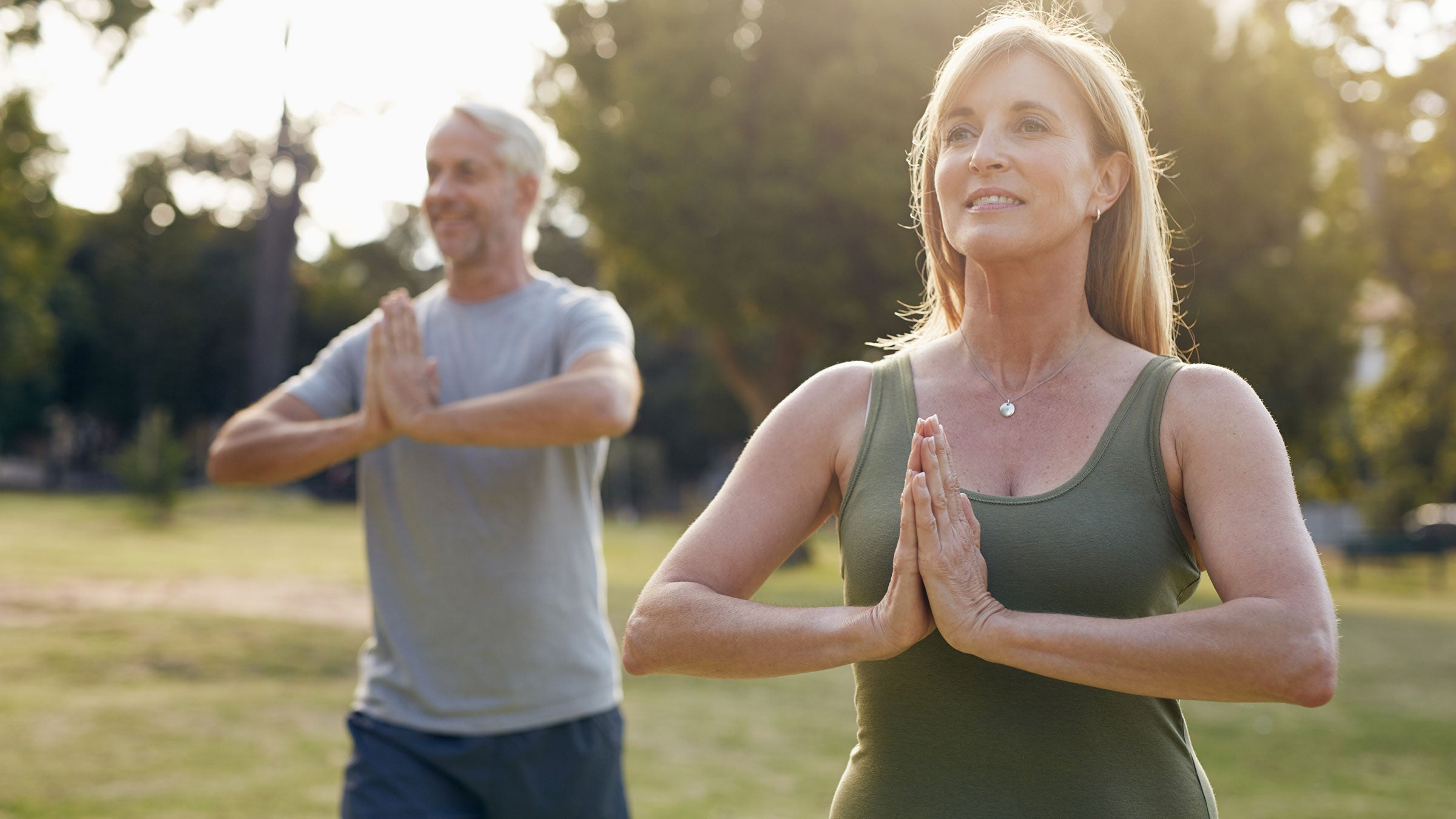 Healthy couple working out doing tai chi in a public park