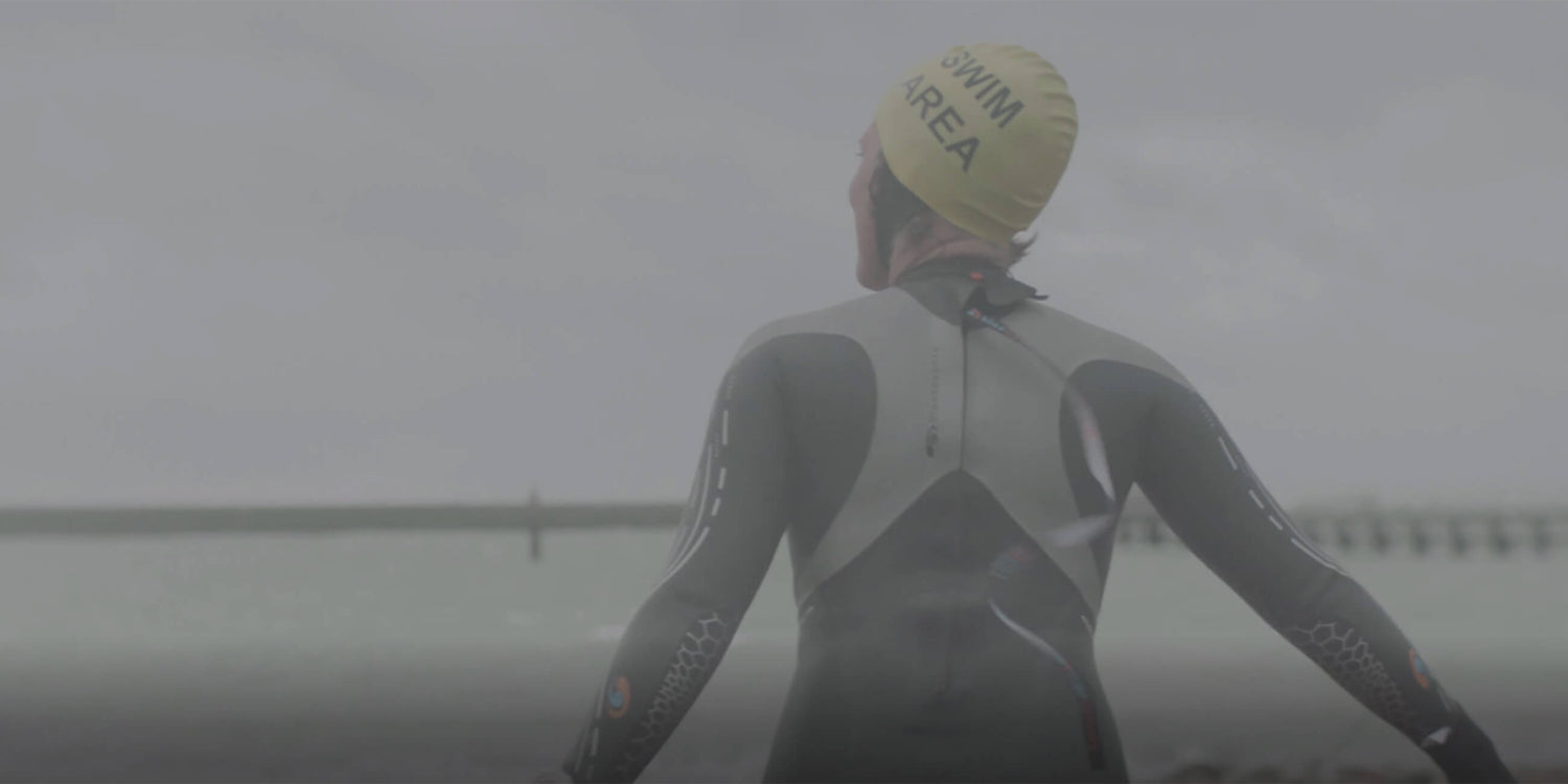 Wild Water Swimmer Louise Edmunds, a Solgar buyer running towards the sea wearing a wetsuit