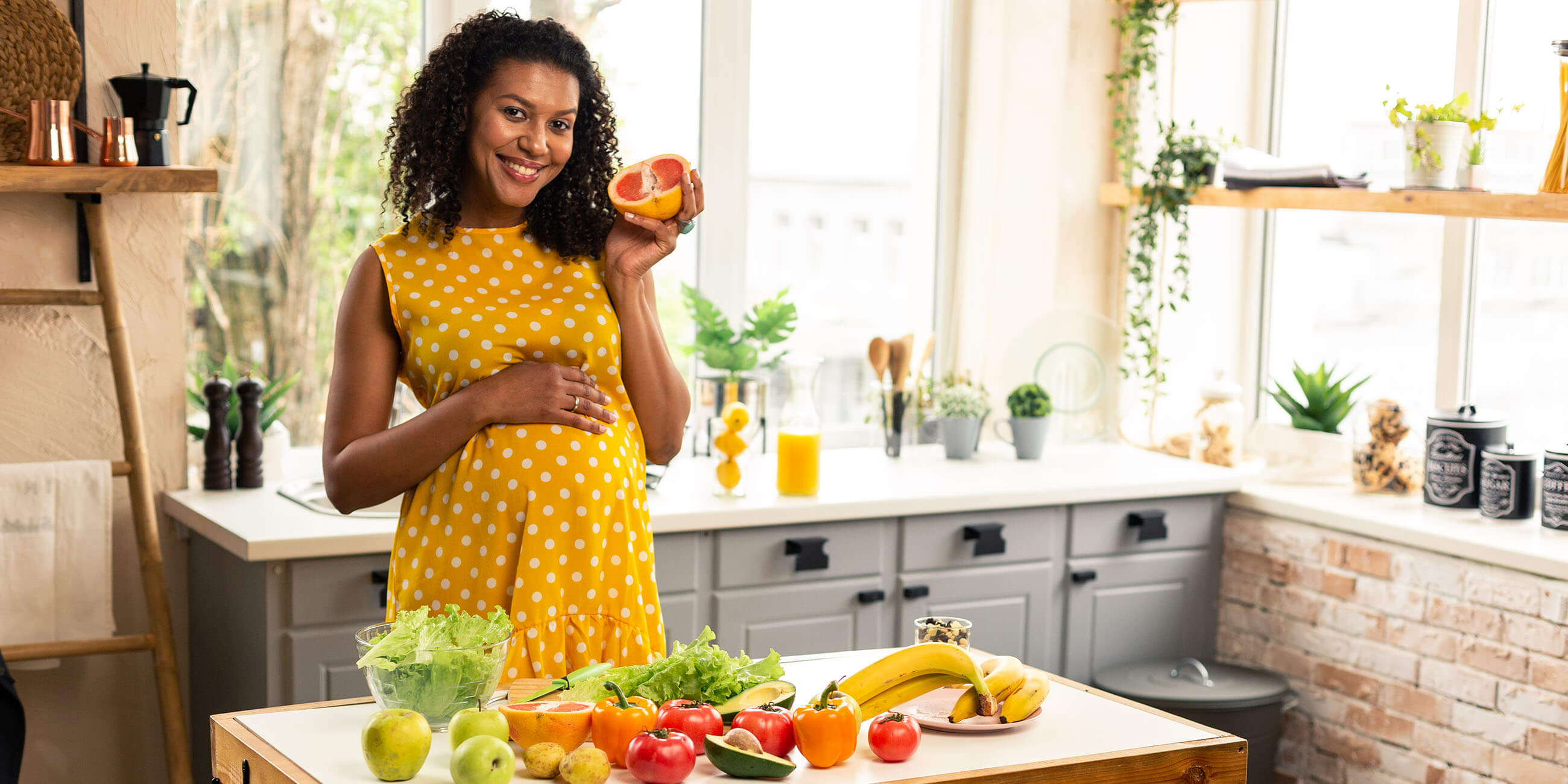 Pregnant woman in her kitchen eating nutricious foods
