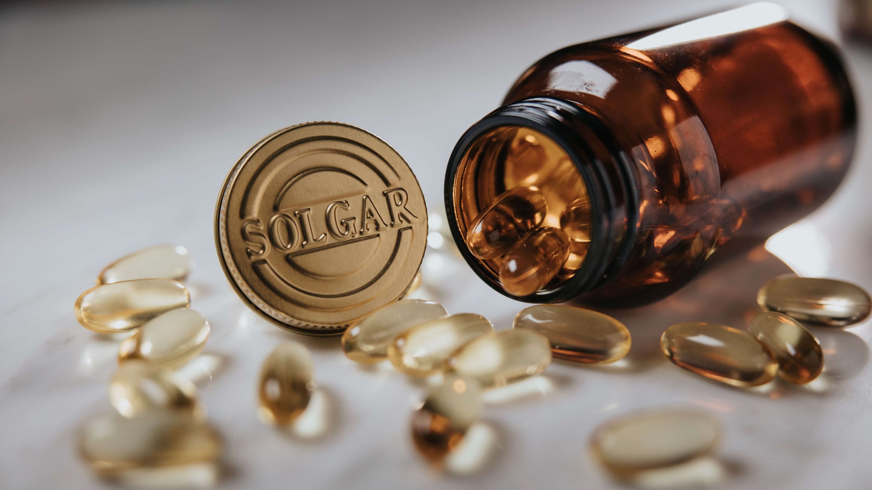Solgar Glass jar with clear Tablets spilling out onto a table