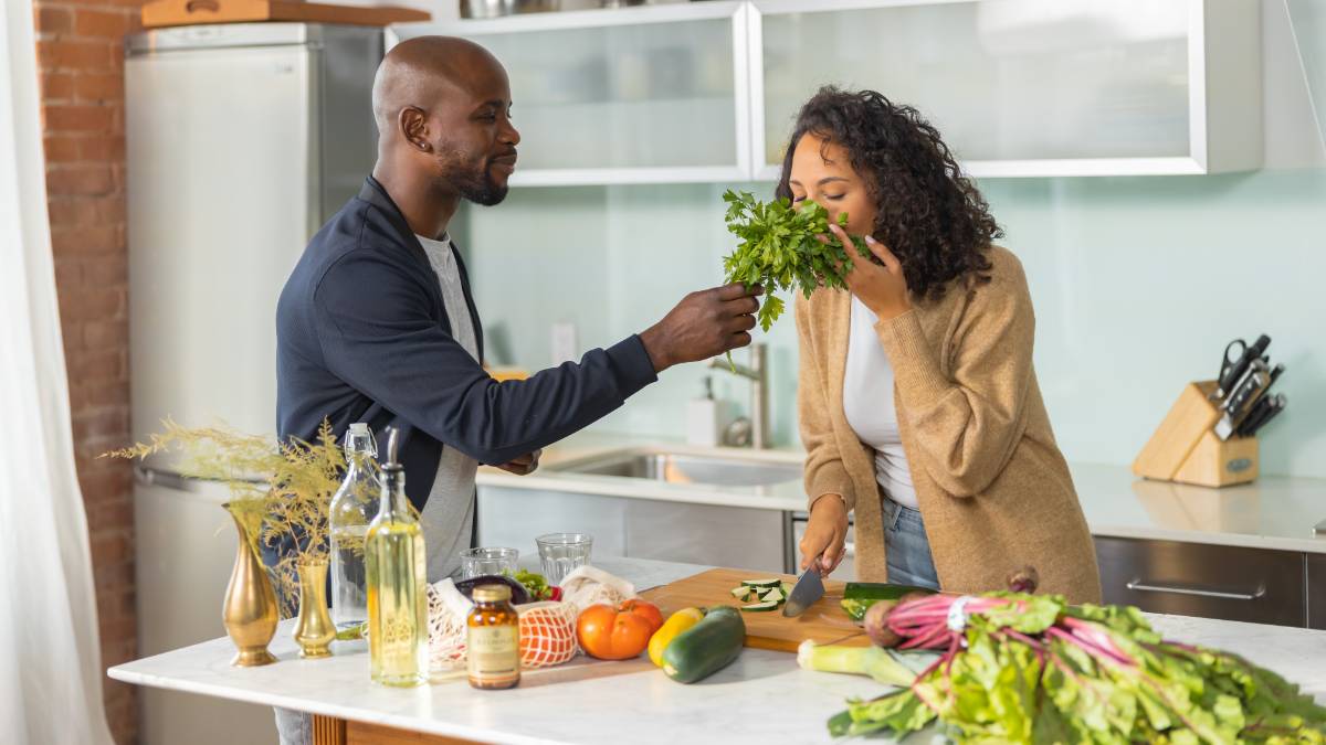 Couple in their kitchen cooking vegan meals together 