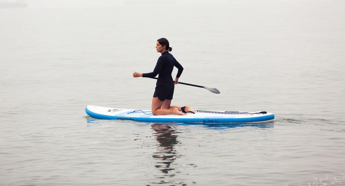 Woman paddle boarding in the sea holding a paddle in her hand