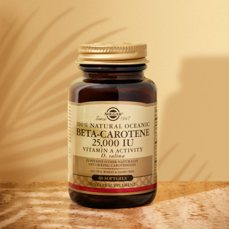 Solgar Natural Source Oceanic Beta-Carotene Softgels on a surface in a glass bottle with a gold lid