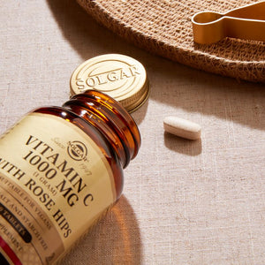 Solgar Vitamin C 1500 mg with Rose Hips tablets in a glass jar on a table