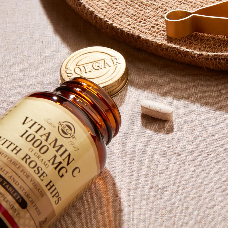 Solgar Vitamin C 1500 mg with Rose Hips tablets in a glass jar on a table