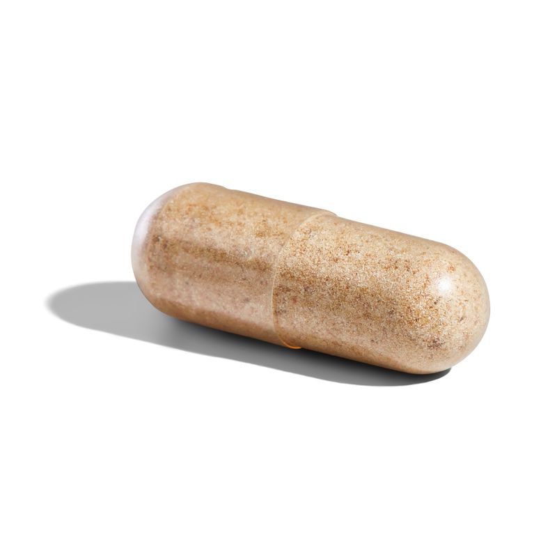 An individual Solgar Advanced Multi-Enzyme Complex vegetable capsule on a surface