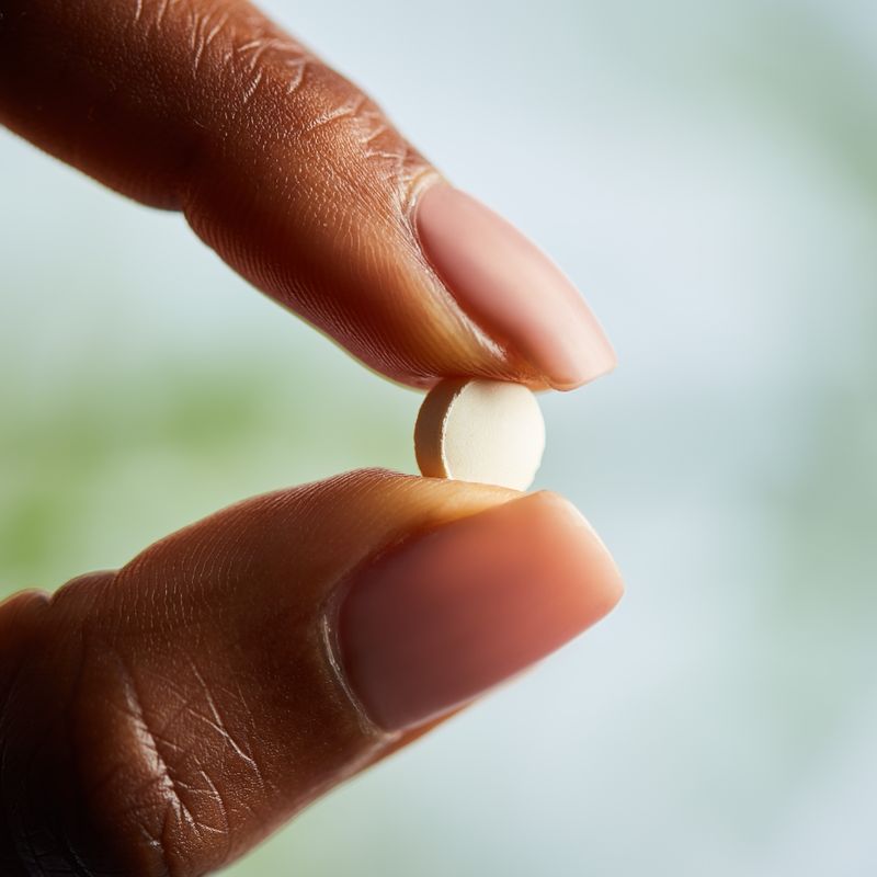 Solgar Folacin (folic acid) tablets in a person's hand
