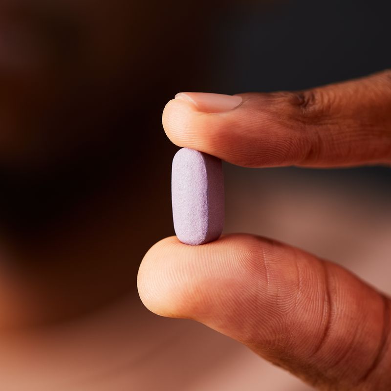 Solgar Omnium Multivitamin Tablet in a person's hand