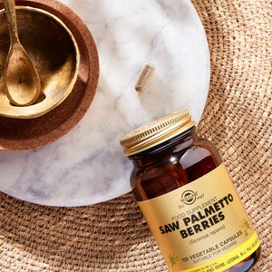Solgar Saw Palmetto Berries vegetable capsules in a glass bottle on a table