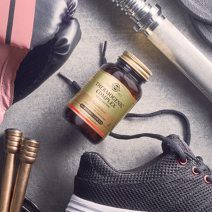 Solgar Thermogenic Complex with Svetol Vegetable Capsules in a glass bottle on the floor alongside some trainers