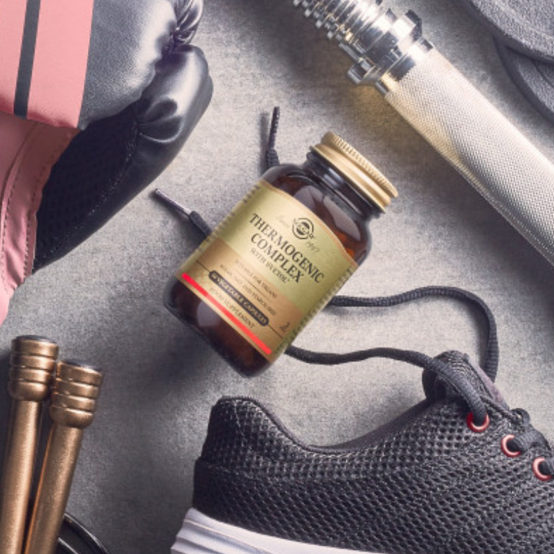 Solgar Thermogenic Complex with Svetol Vegetable Capsules in a glass bottle on the floor alongside some trainers