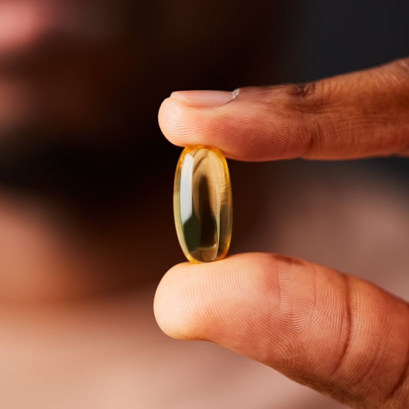 Solgar Omega-3 Fish Oil soft gel in a person's hand