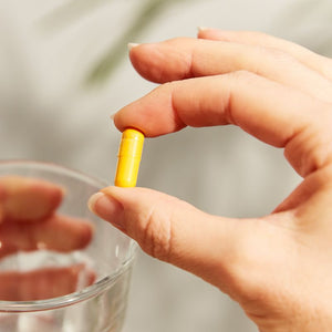 Solgar Turmeric Root Extract vegetable capsules in a person's hand