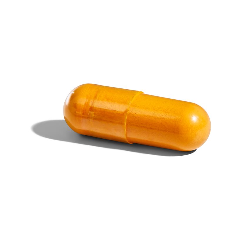 Singular Solgar Turmeric Root Extract vegetable capsule on a white surface