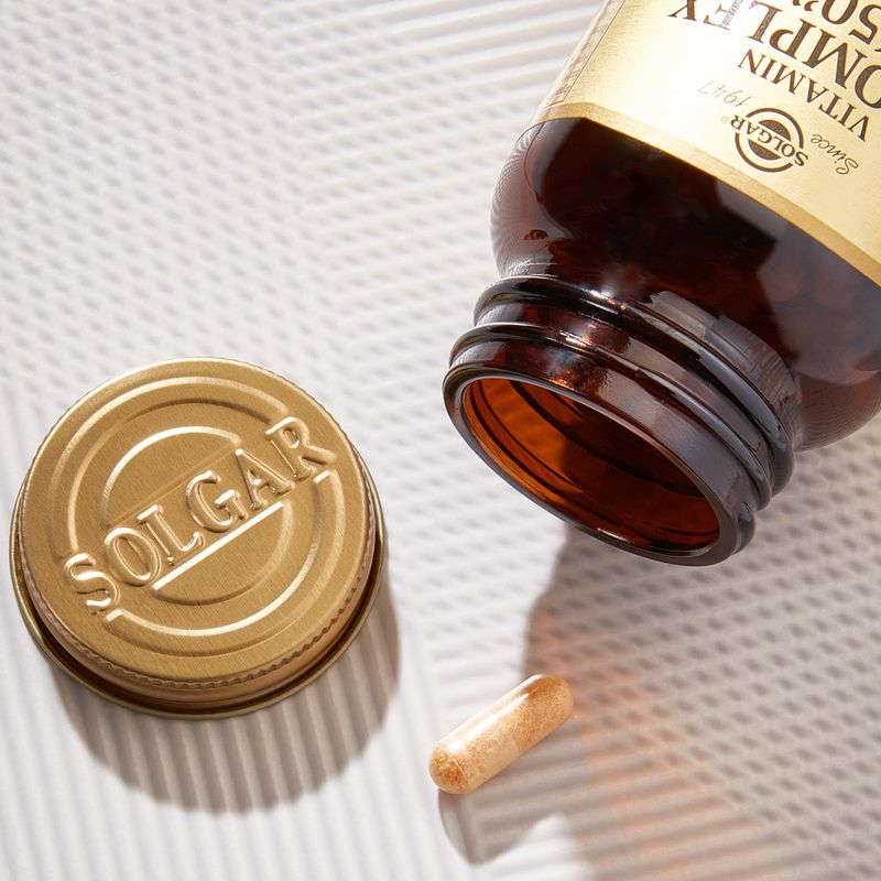 Solgar Vitamin B-complex supplements in a glass bottle on a table