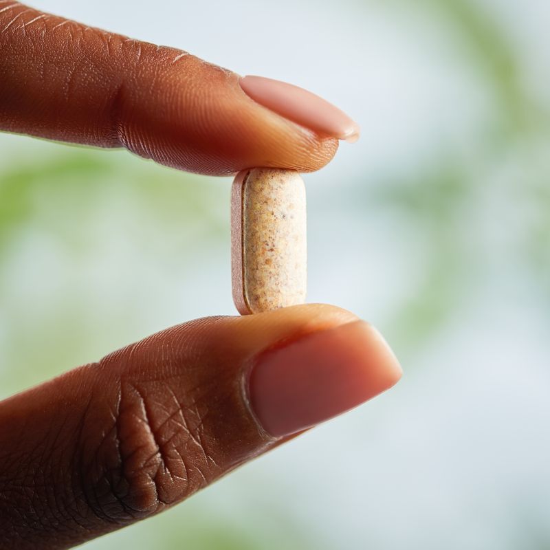 Solgar VM-PRIME multivitamin tablet in a person's hand