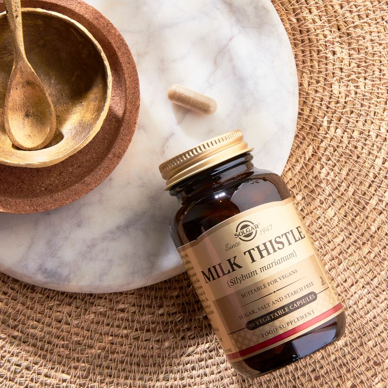 Solgar Milk Thistle capsules in a glass jar on a table