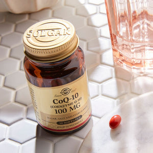 Solgar CoQ-10 100 mg Softgels in a glass bottle on a table